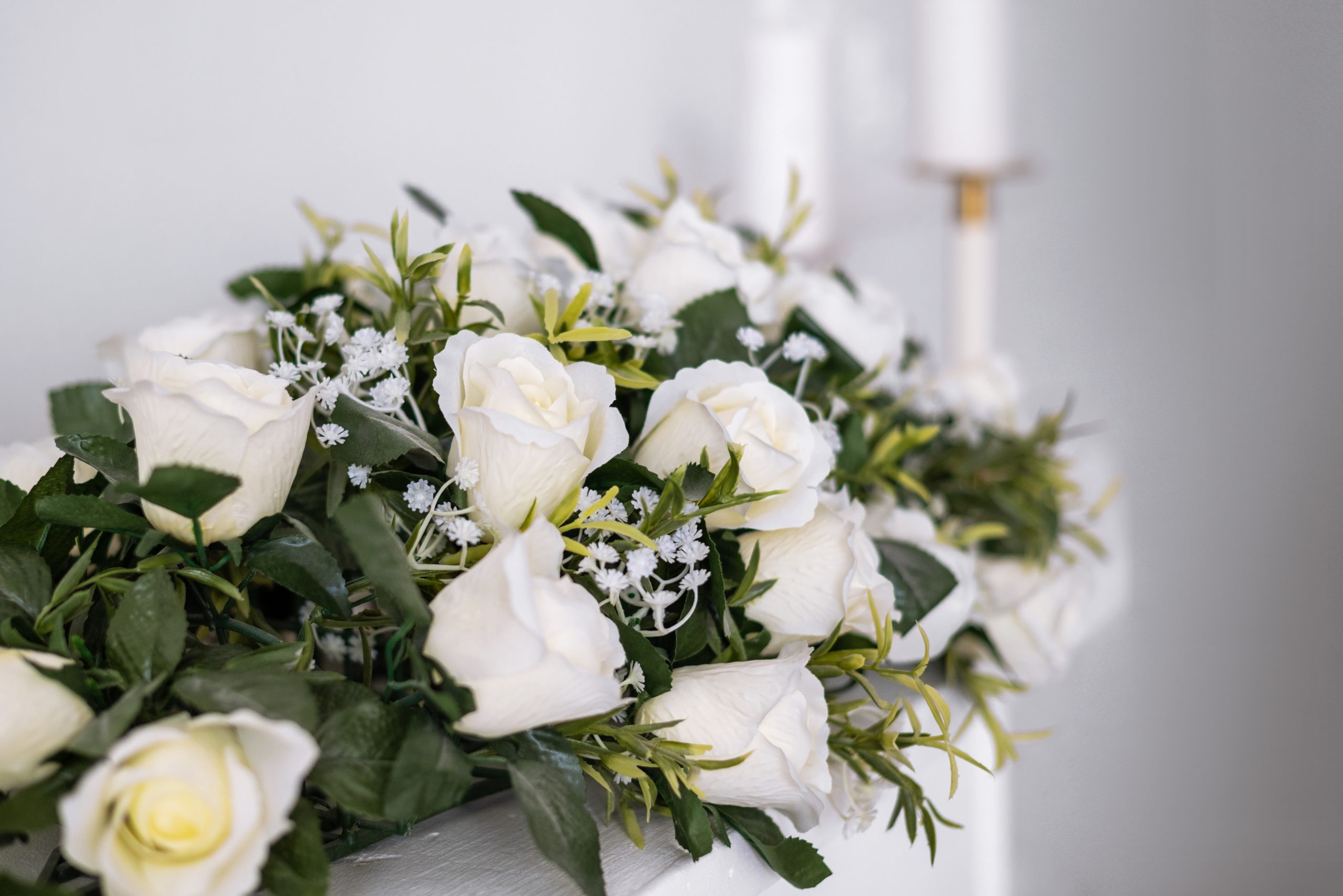 Decorative flower arrangement of white roses on the fireplace